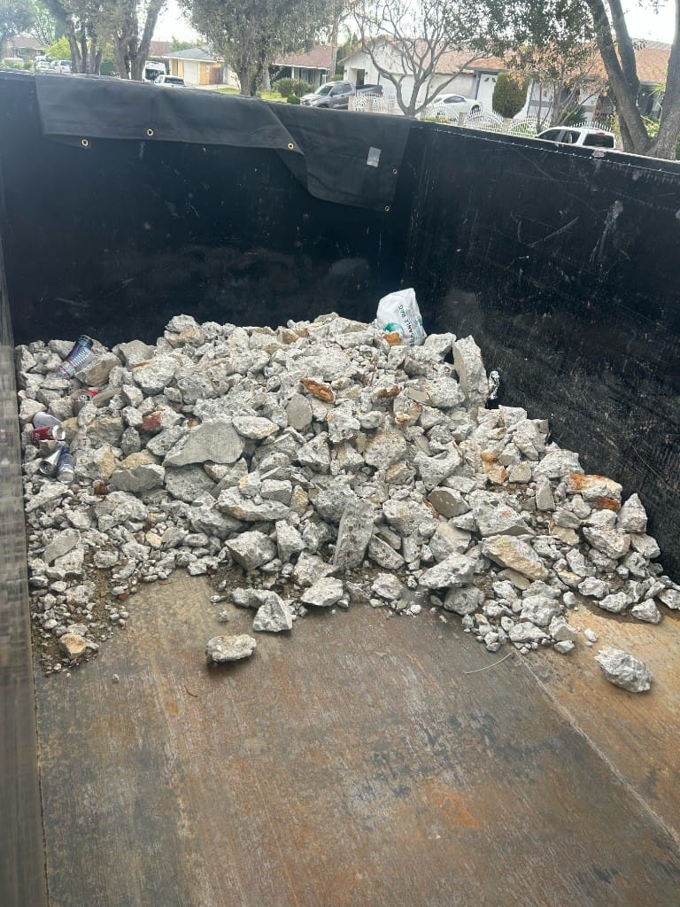 Heavy concrete and mixed debris staged for professional hauling